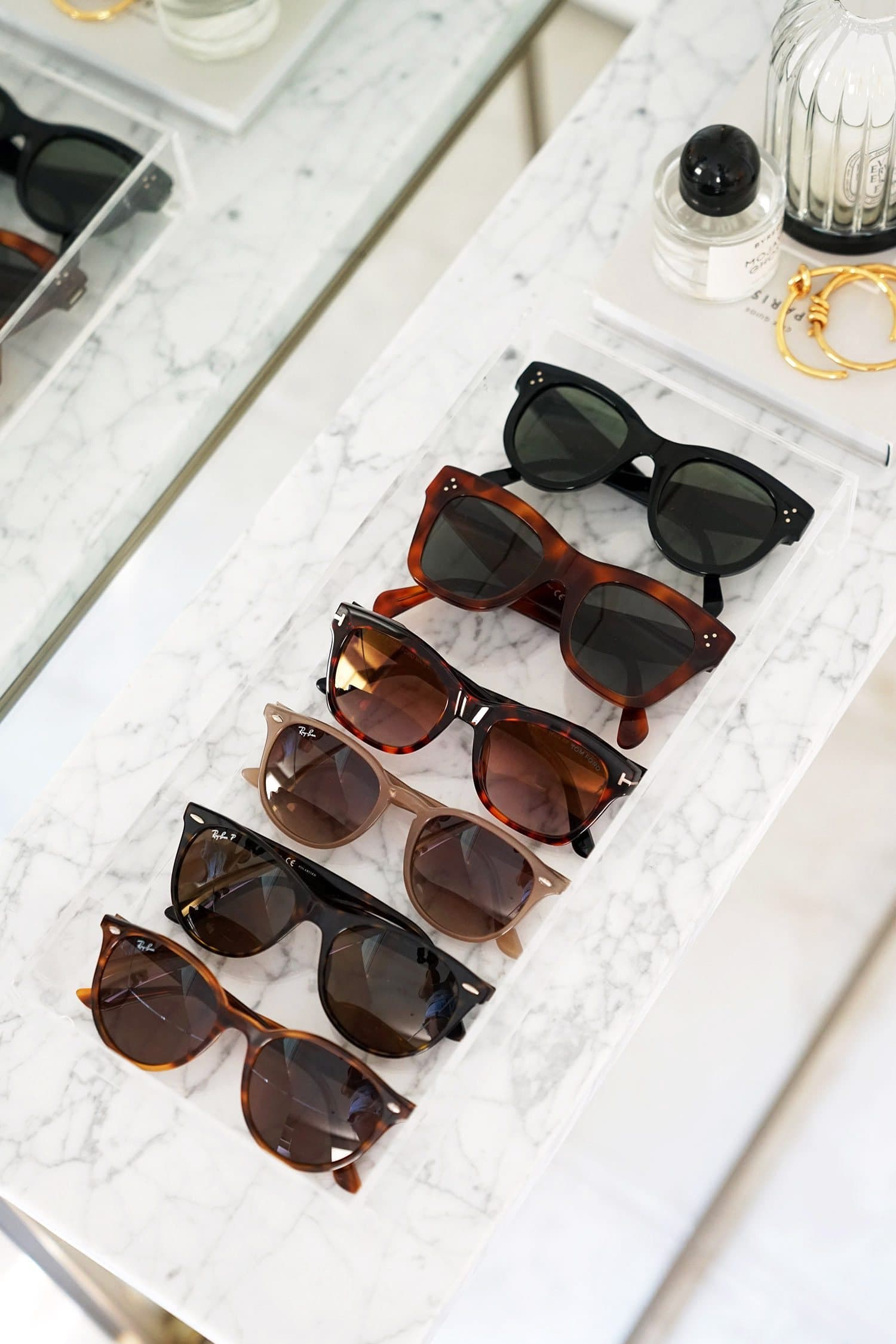 A collection of sunglasses on a marble tray
